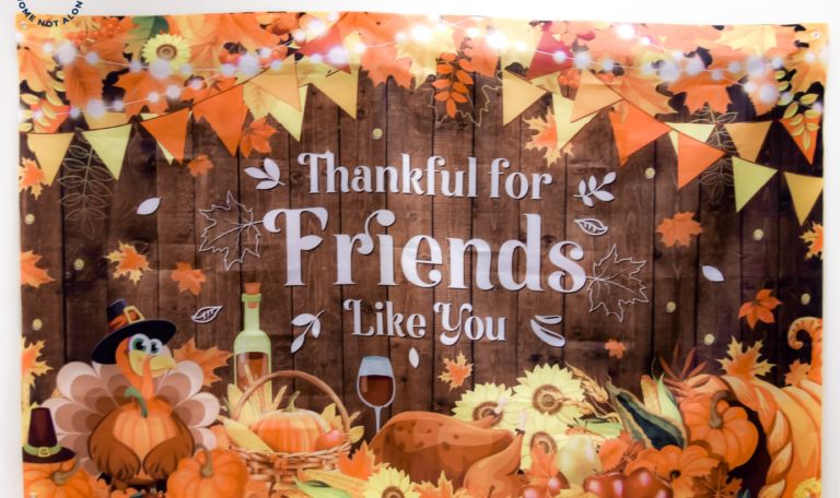 A vibrant 'Thankful for Friends Like You' banner with colorful fall-themed designs, including pumpkins, leaves, and decorative bunting at the Thanksgiving 2024 'Friendsgiving' Event by Home Not Alone Caregiver Services for individuals with intellectual disability (IDD) within residential group homes and accessible family group homes in Allegheny County, Pittsburgh, Pennsylvania.