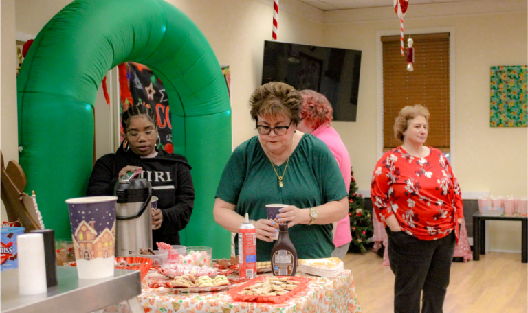 Attendees of family members and staff of the holiday event gathered around tables, engaged in conversation, and enjoying the festive atmosphere. Home Not Alone Christmas Event 2024/ Holiday Event in Holiday Season by Home Not Alone Caregiver Services for individuals with intellectual disability (IDD) within residential group homes and accessible family group homes in Allegheny County, Pittsburgh, Pennsylvania.